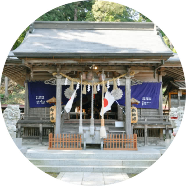 日本の伝統的な神社の拝殿。しめ縄と日本国旗が飾られ、紫色の幕には装飾が施されている。